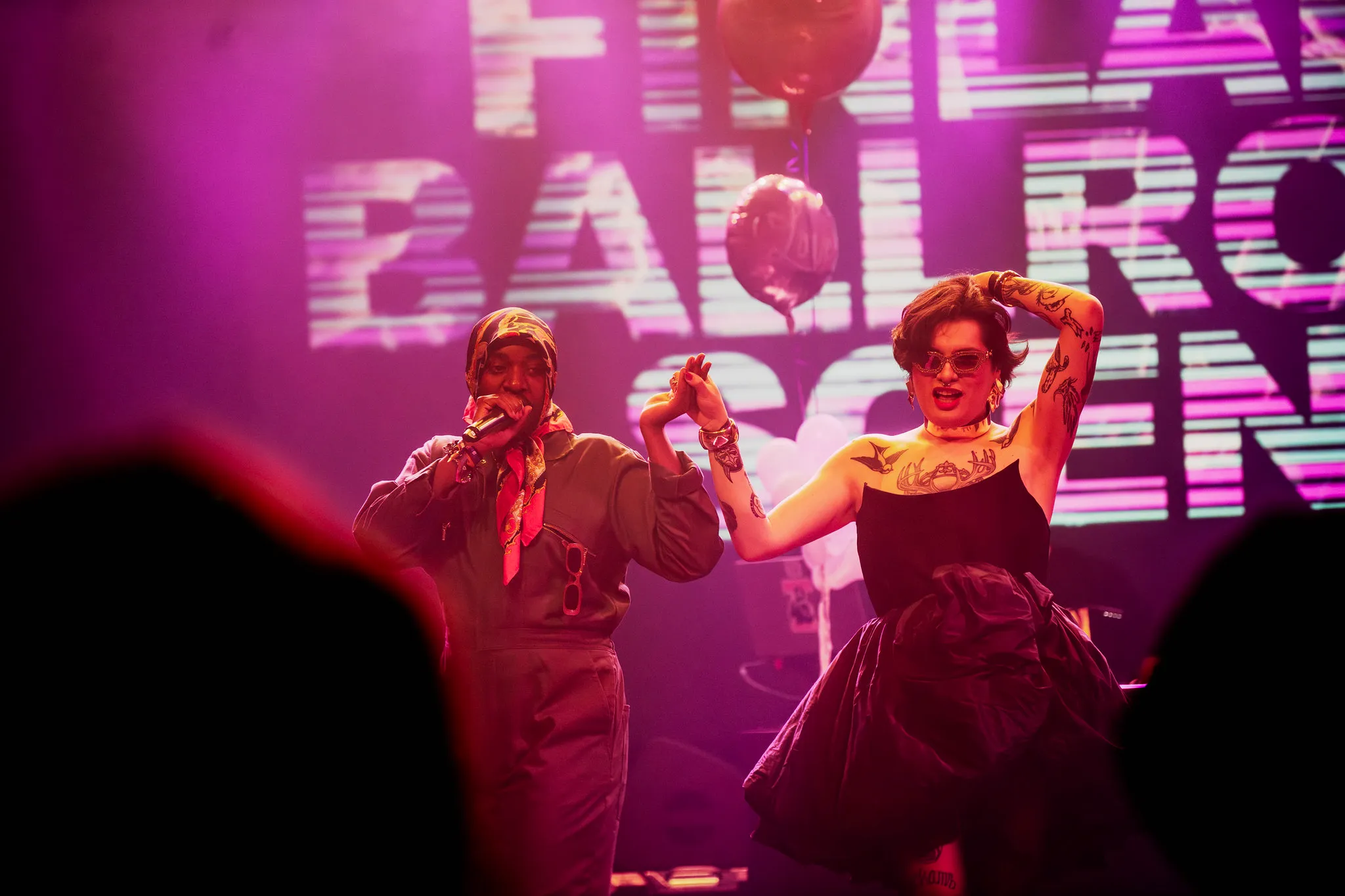 Two performers in front of a screen reading Finland Ballroom Scene