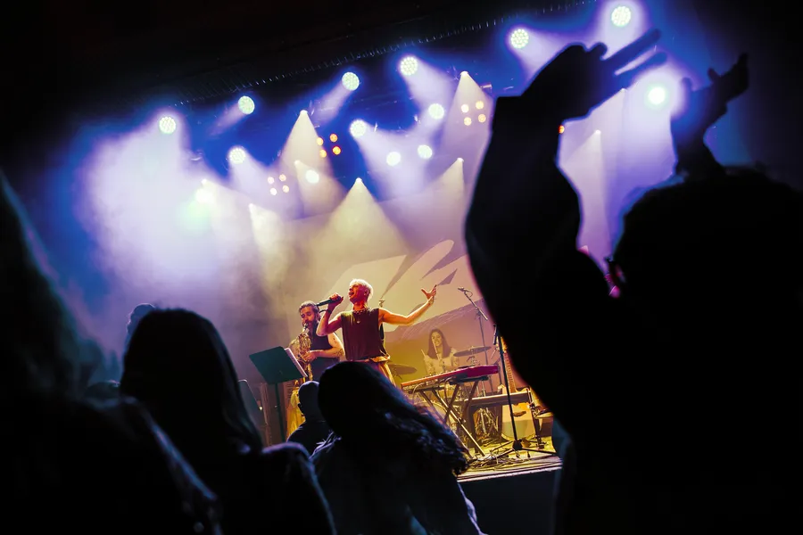 Hands in the air in blue and white stage light