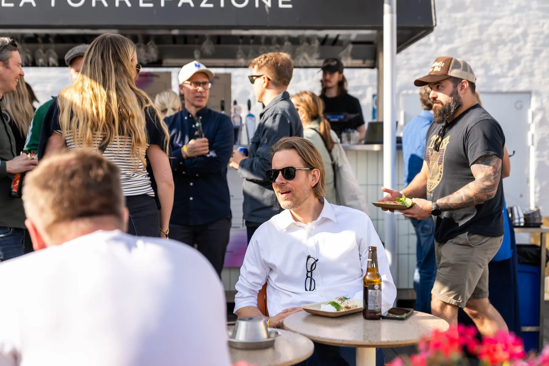 People eating and talking on a sunny café terrace