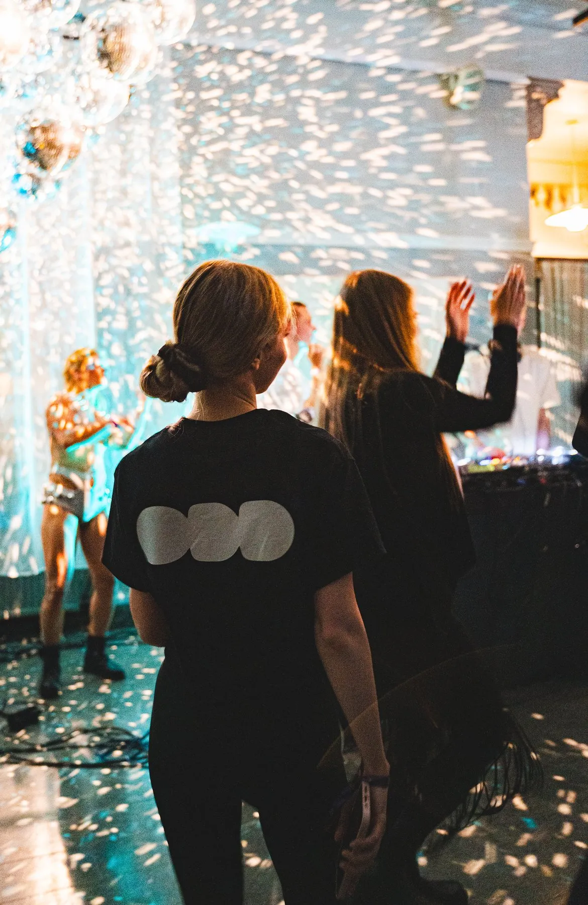 People dancing under falling confetti, one in an ODD T-shirt