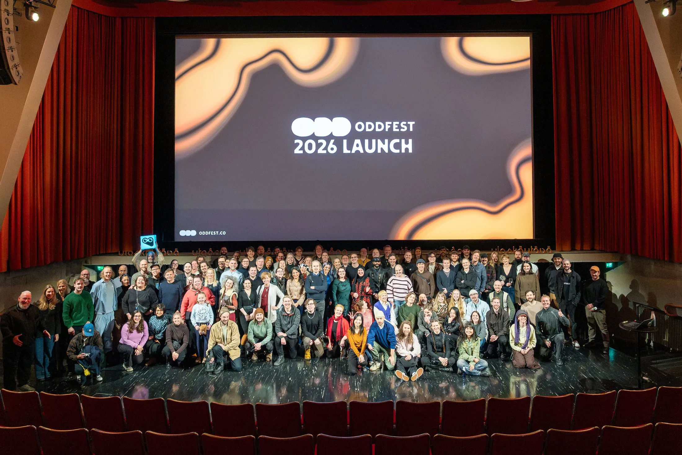 The ODDfest 2026 launch: a large group of people gathered on a theatre stage under a screen reading ODDfest 2026 Launch