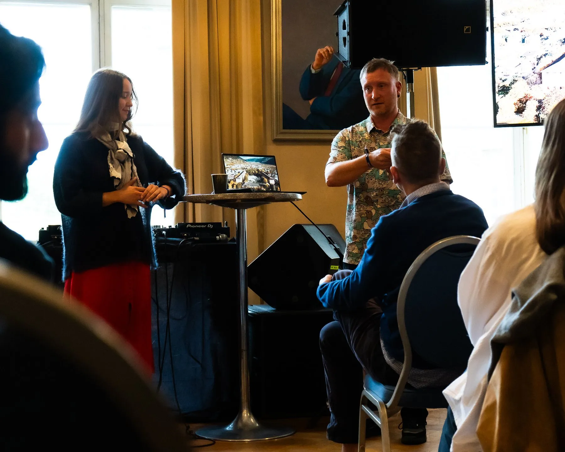 Two hosts leading a session for a small seated group in a bright room
