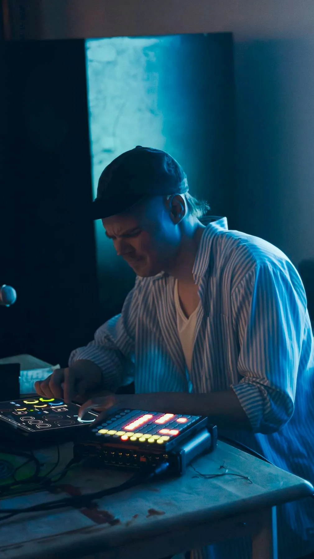 A musician playing live electronics under blue light