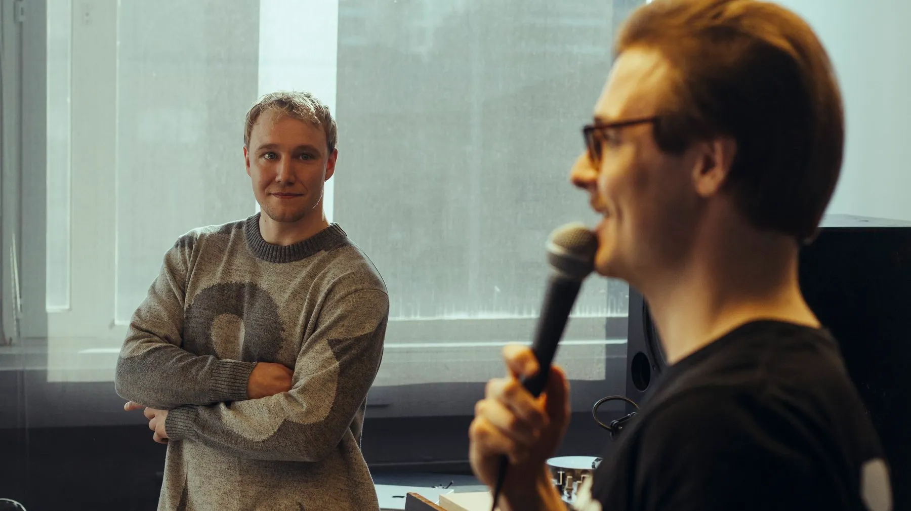 One host listening while another speaks into the microphone