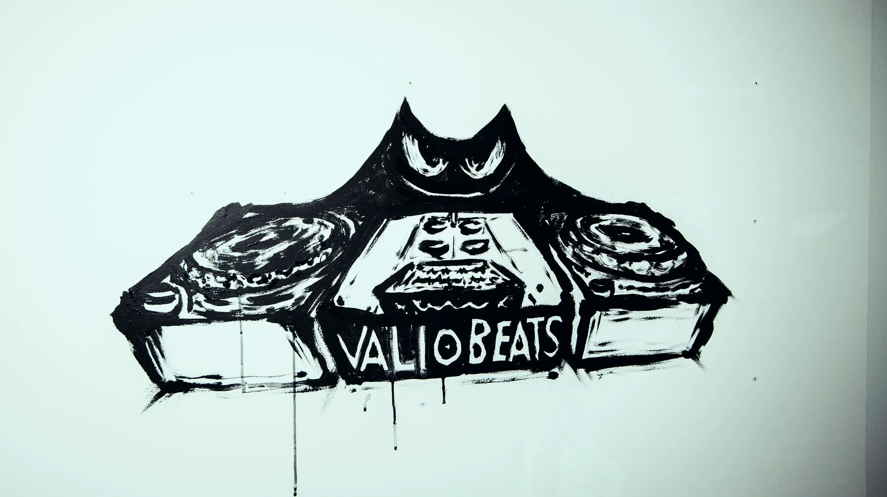 A finished black-ink Valio Beats mural on a white wall