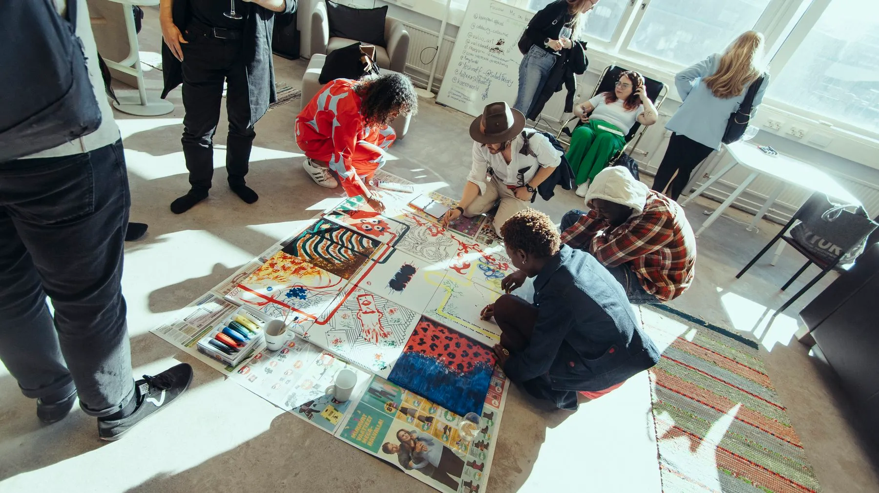 People painting together on paper spread across the floor