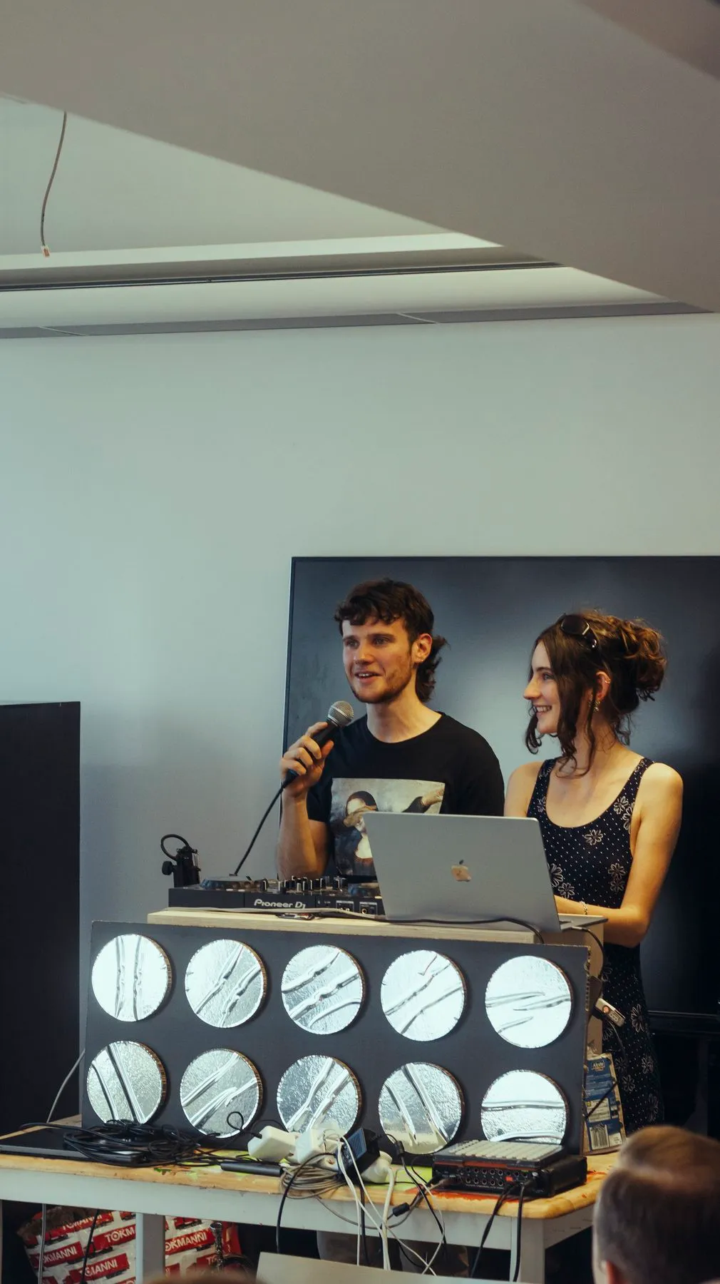 Two presenters with a microphone at the DJ booth