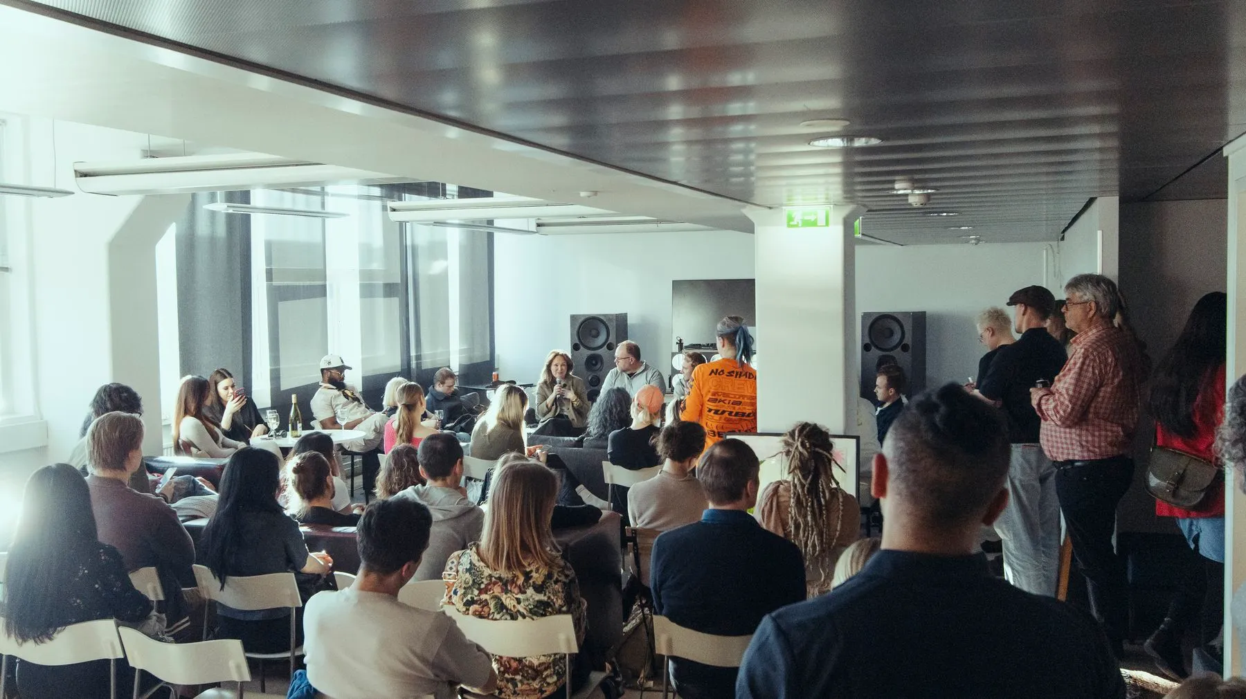 A seated crowd facing a speaker in the ODDspace lounge
