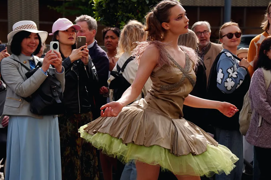 A dancer in a tulle skirt performing to passers-by on the street