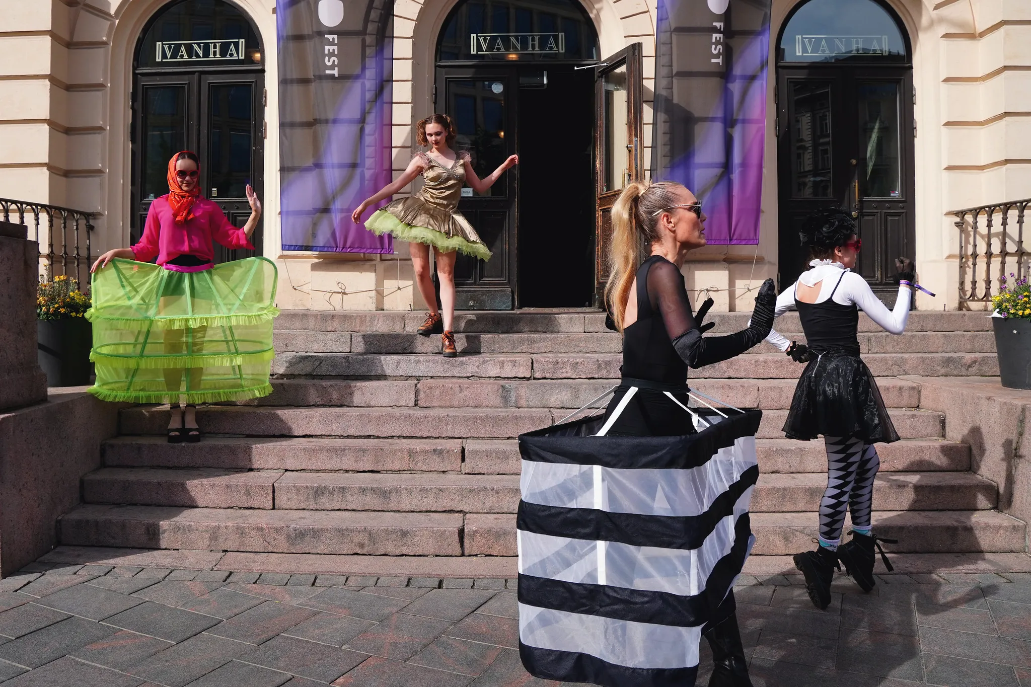 Dancers in tulle skirts performing on the steps outside Vanha Ylioppilastalo